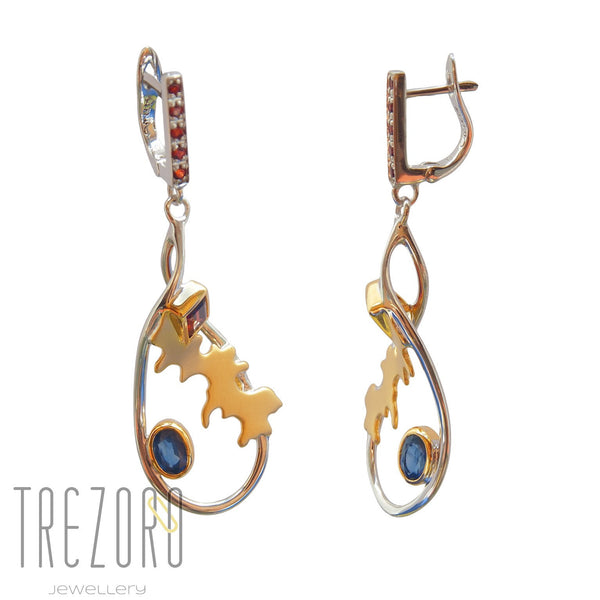 Adventure Road Designer Earrings. Sterling Silver with Garnet Sapphire. Rhodium and Gold Plated. On white.